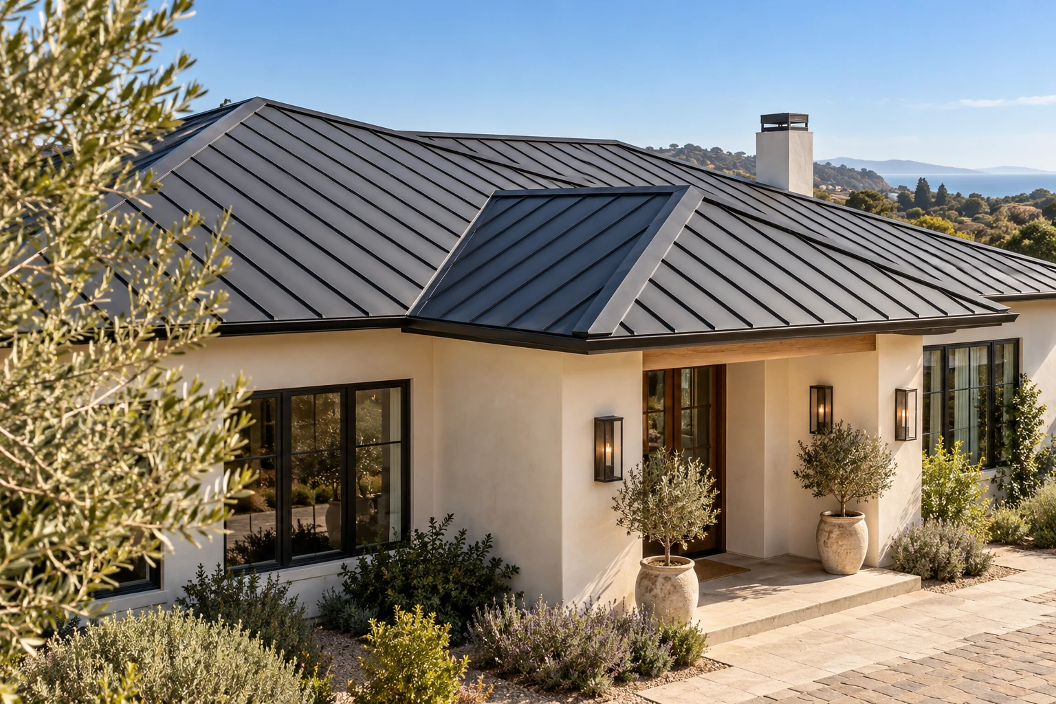 Dark standing-seam roof and eaves over a warm stucco home